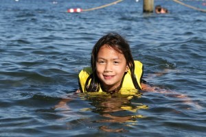 A girl in a lifejacket swimming