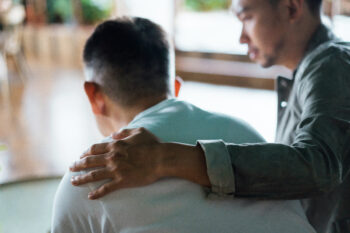 A father comforts a teen son