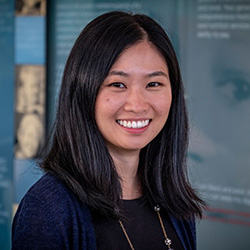 A close up photo of a woman with black hair smiling at the camera