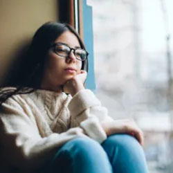 A teenage girl looks out a window