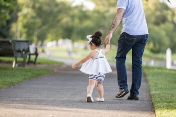 A girl walks with her father