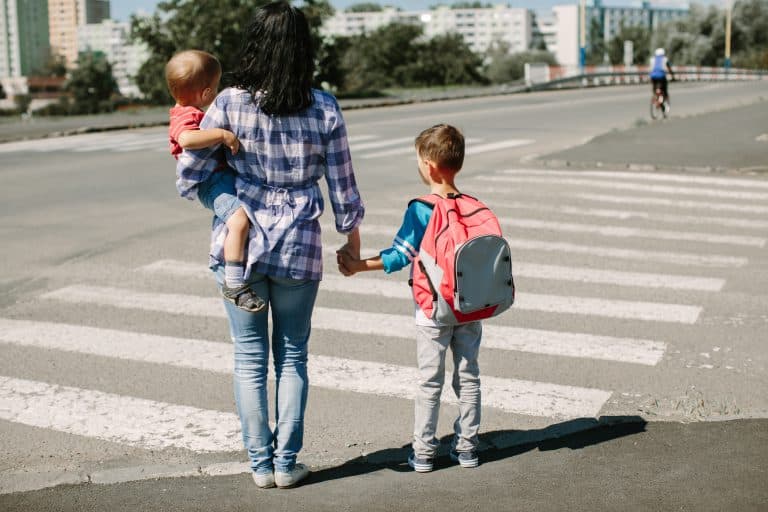 A family crosses a road together safely.