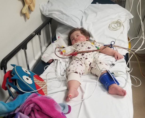 A toddler laying in a hospital bed