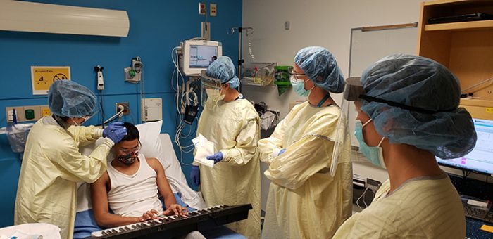 Irene and the care team prepare to access Malachi’s port for treatment. Malachi loves playing the piano; he’s pictured here using his seven-hour brain infusion treatment session to practice.