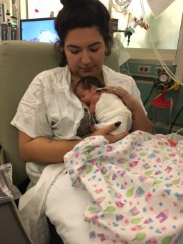 a mom cuddles her infant daughter in the hospital