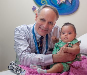 A doctor poses with his little patient