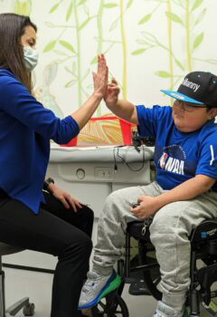 A boy high-fives his Seattle Children's provider