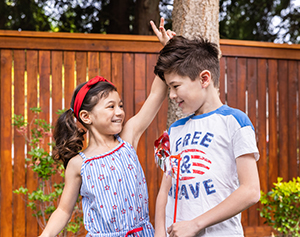 a brother and a sister playing in the backyard