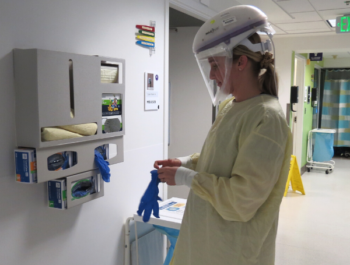 A healthcare provider dons protective gear