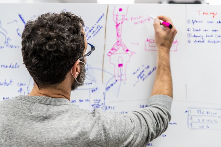 A doctor writes on a whiteboard