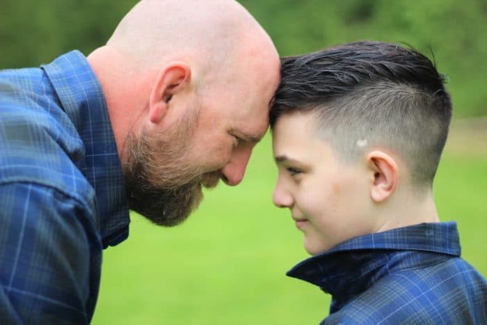 dad and son with their heads together