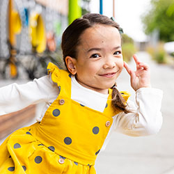 A girl in a yellow dress poses for the camera