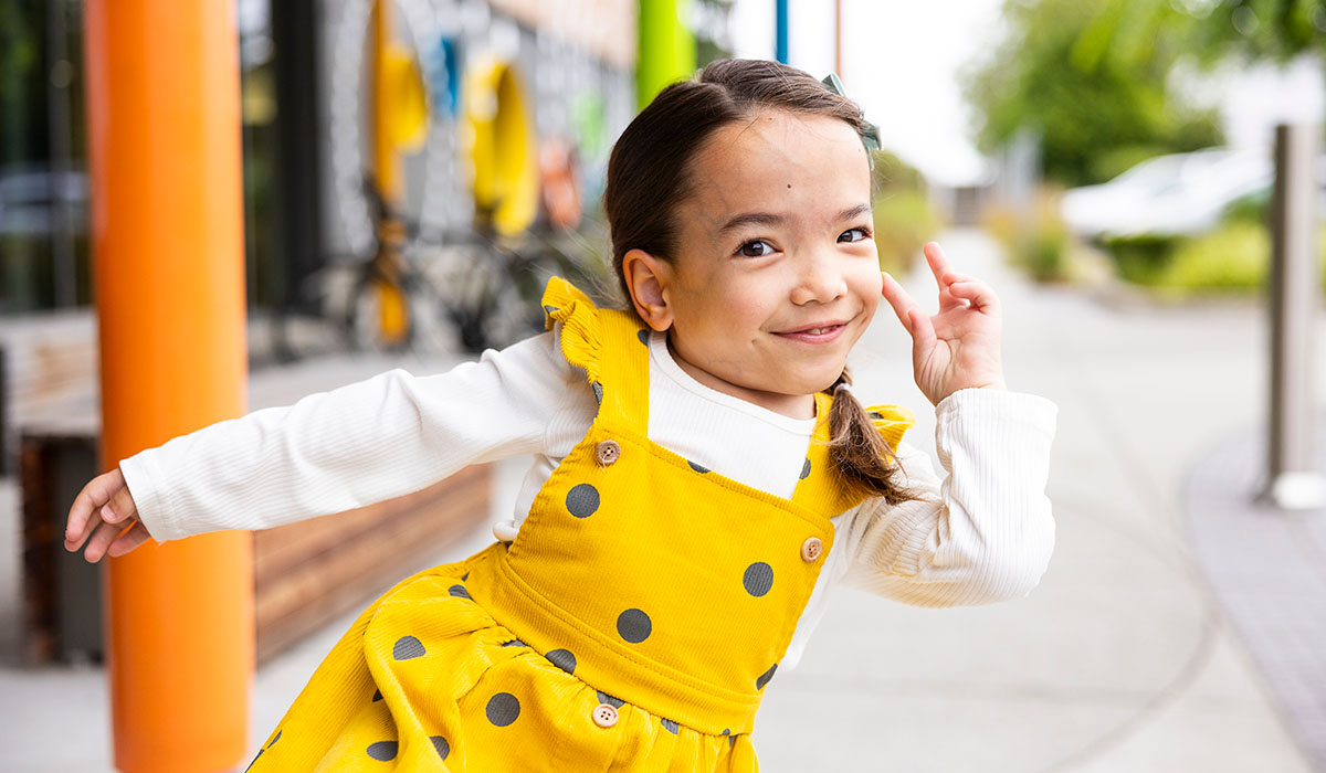 A girl poses for the camer in a yellow dress