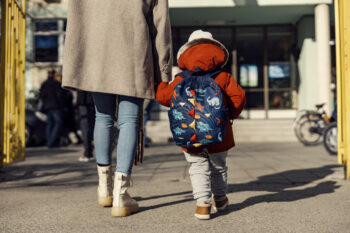 A child walks to school with a parent