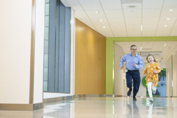 A little girl races her doctor down the hall at Seattle Children's Hospital