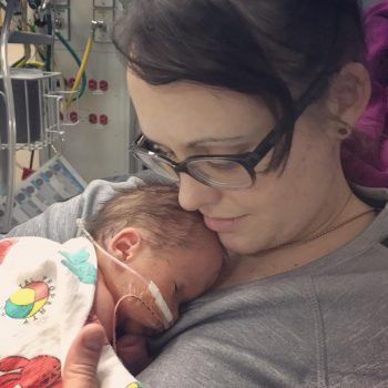 a mom cradles her newborn son on her chest