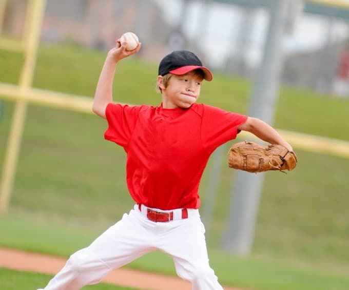 Child pitching a baseball.