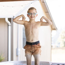 A boy stands in a hot tub