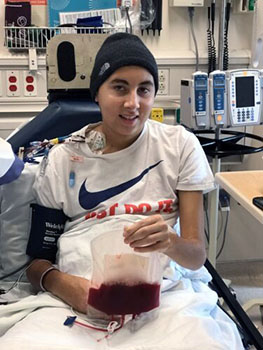 Jedd holds a bag containing his reprogrammed T cells during cancer immunotherapy treatment at Seattle Children’s