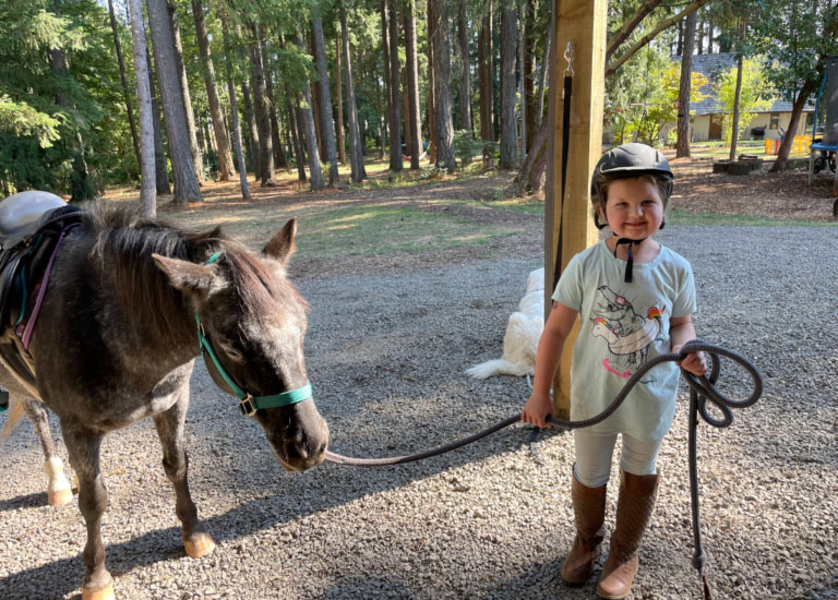 A girl holding the reins of a horse.