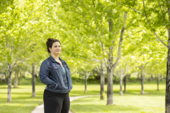 A young woman stands in a park