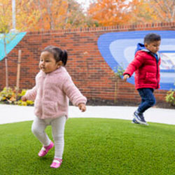 Two kids playing outside in winter coats