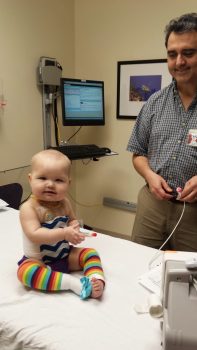 Little girl sitting on hospital bed