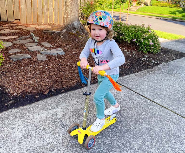 A girl rides a scooter