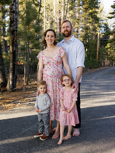 A woman, man, young boy and young girl pose outside for a family photo.