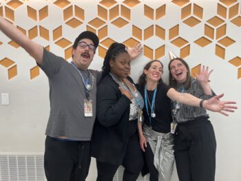 four people posing as a group for the photo