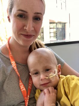 a mom cuddles with her son while in a hospital room