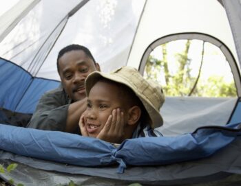 A boy and his father in a tent