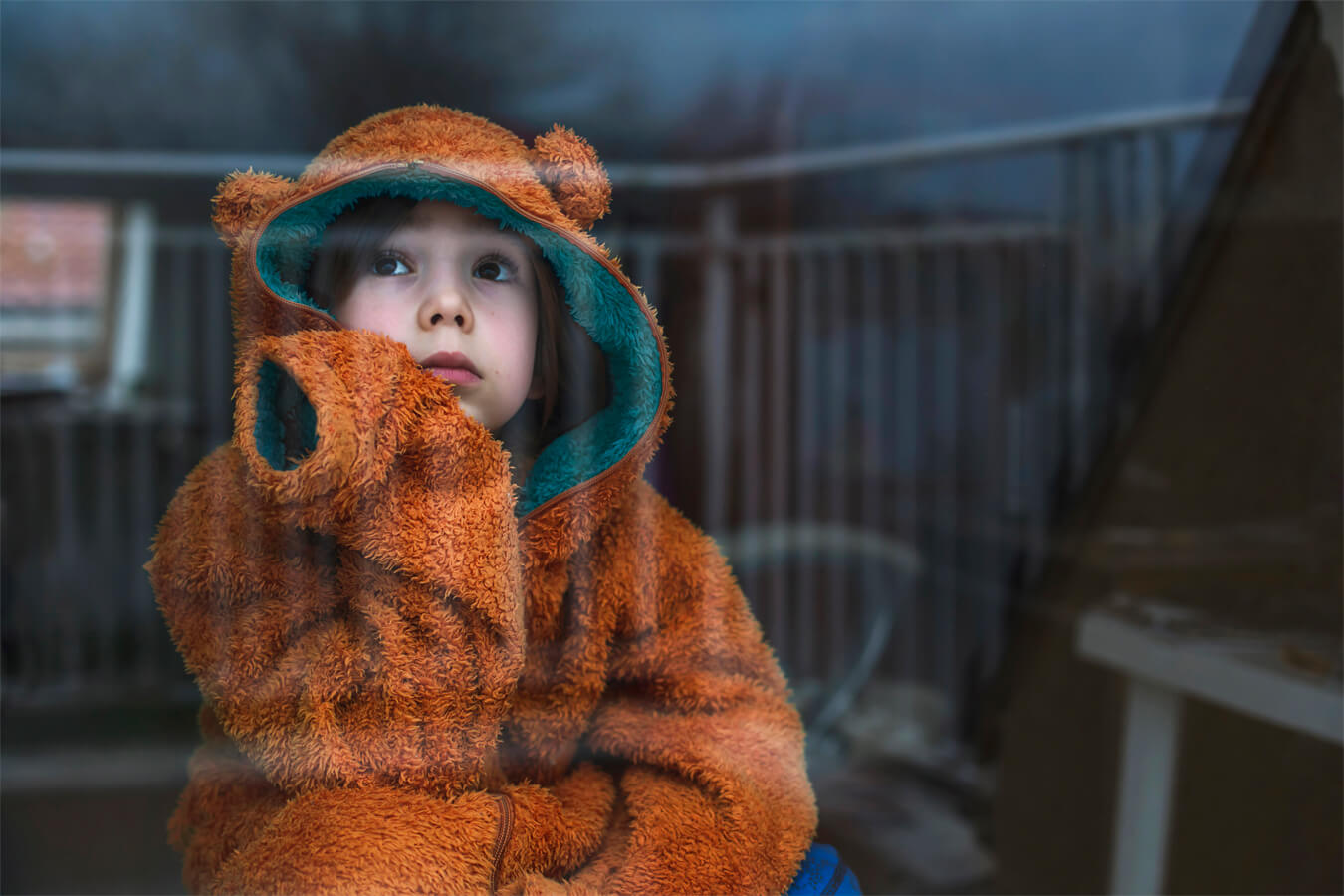 Boy looking through glass window