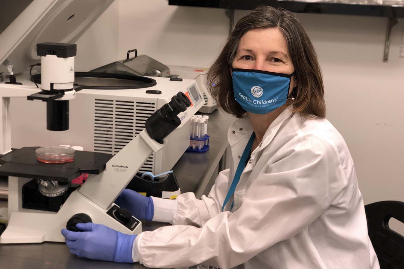 Dr. Lawlor uses a microscope at Seattle Children's Research Institute