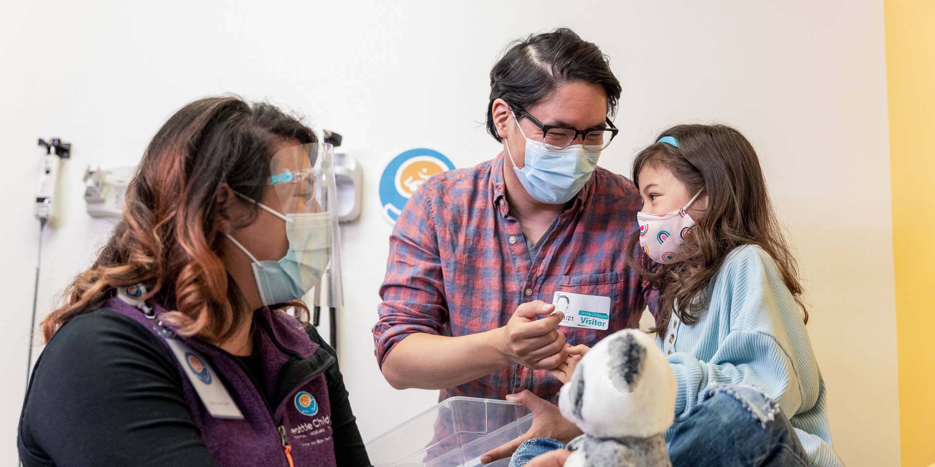 A father and daughter speak to a healthcare employee.