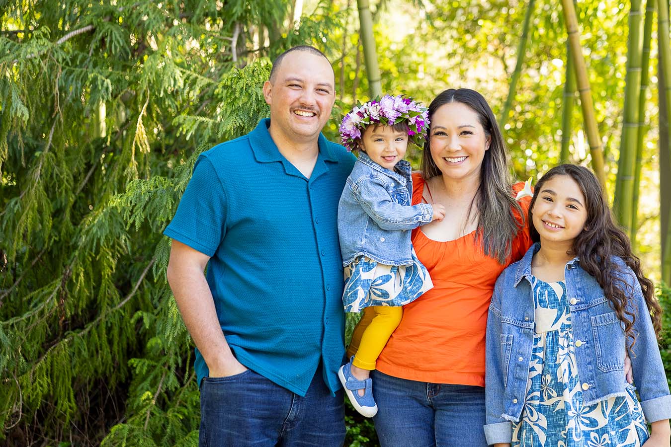 A family stands in front of bamboo