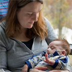 Mother holding sleeping infant in her arms