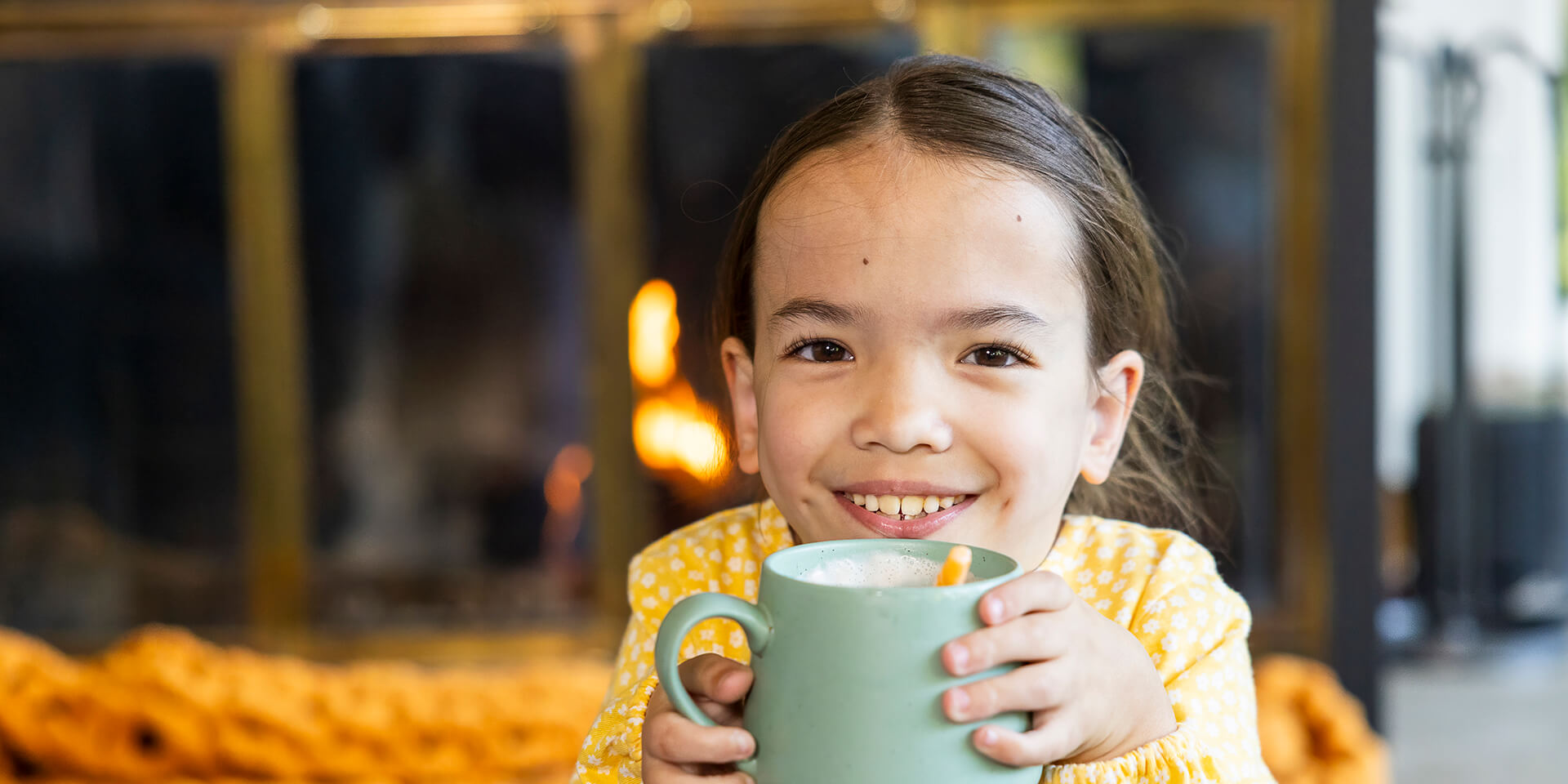 Smiling child holding mug