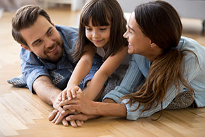 A family plays together on the floor.