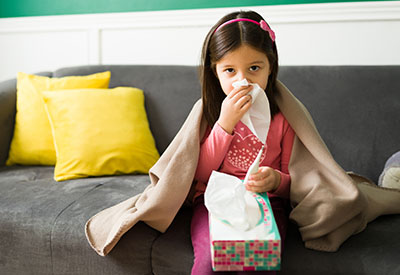 A girl dabs her nose with a tissue