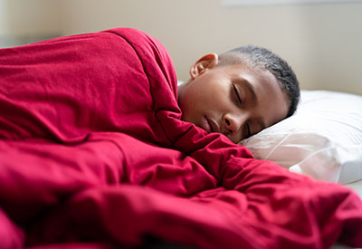 A boy sleep in bed