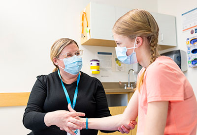 A Seattle Children's provider check's a patient's arm