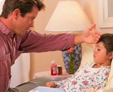 father checks child's head for fever