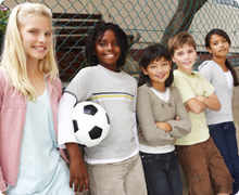 Kids looking at the camera with a soccer ball