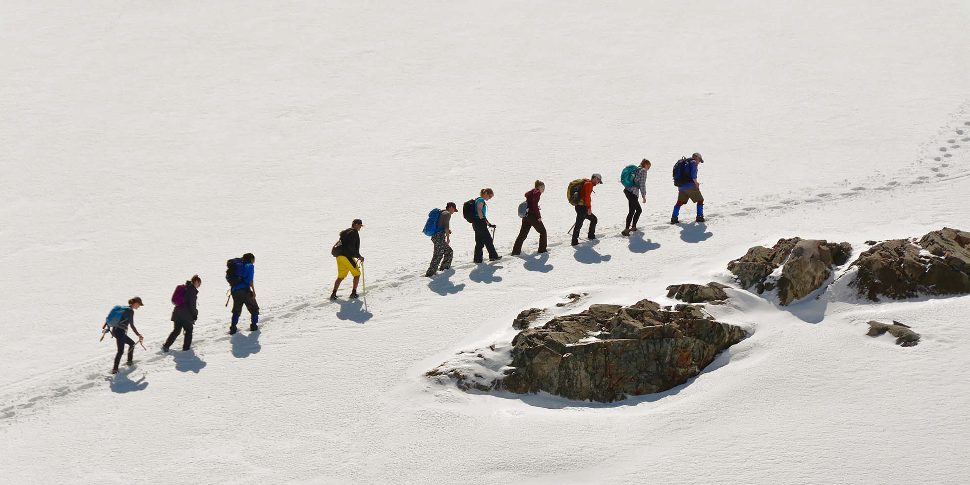 Residents walk along a snowy mountain