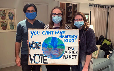 Residents hold up a sign that reads "You can't have healthy kids on a sick planet"