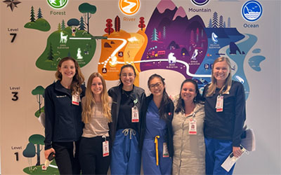 A group of residents stand in front of wall art at Seattle Children's Hospital