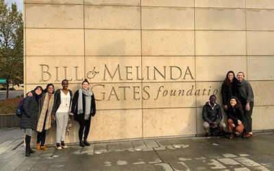 Residents stand next to a "Bill & Melinda Gates Foundation" sign