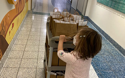 A child pushed a cart with brown bags on it