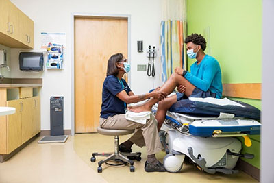 A Seattle Children's doctor examine's a patient's leg